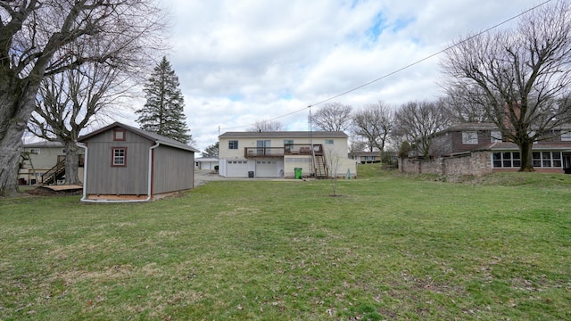 view of yard with a shed, a wooden deck, stairs, an outdoor structure, and a garage