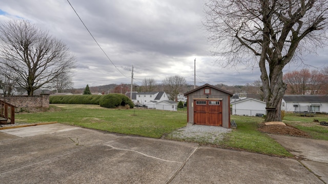 view of yard featuring an outdoor structure, a storage unit, and fence