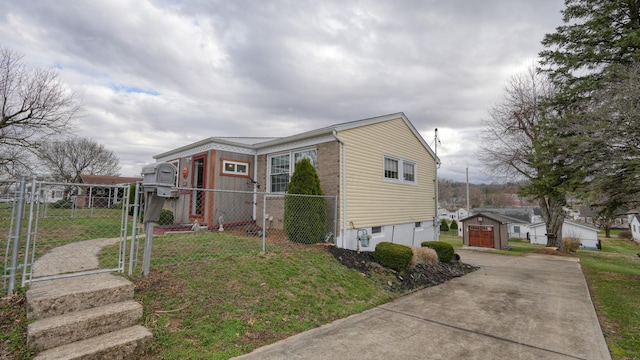 view of home's exterior with an outbuilding, fence, a lawn, and driveway