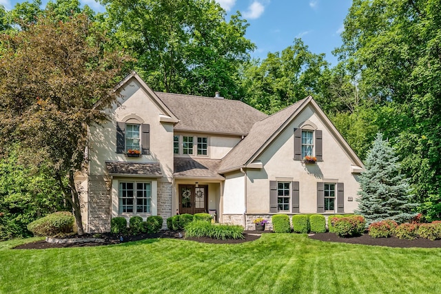 9047 Sequoia Ct, Plain City, OH 43064 - view of front of home with stucco siding, stone siding, a front yard, and roof with shingles