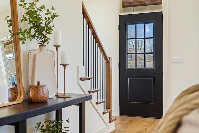 foyer featuring light wood finished floors and stairway