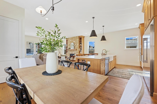 dining space with recessed lighting, light wood-style flooring, and baseboards