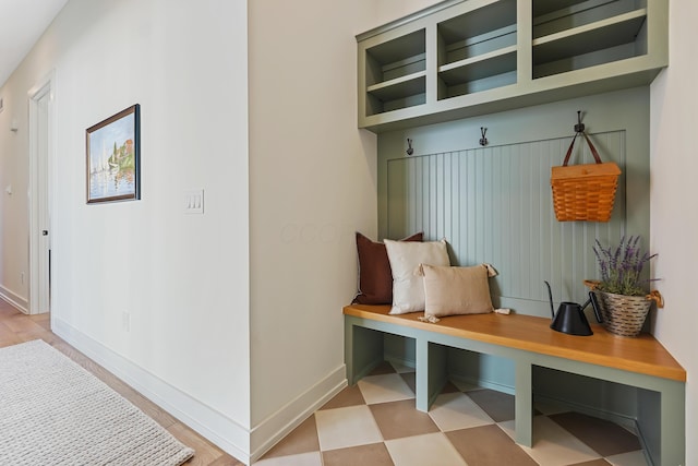 mudroom featuring baseboards and light floors
