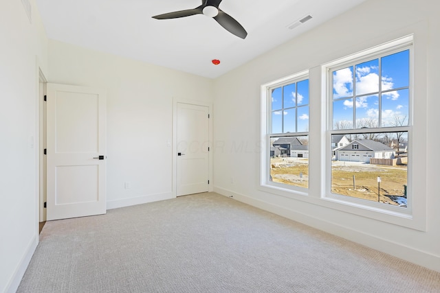 unfurnished room featuring visible vents, baseboards, carpet, and a ceiling fan