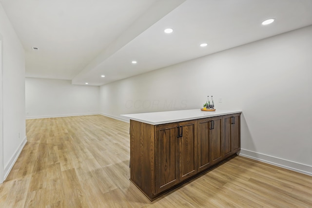 bar featuring light wood finished floors, recessed lighting, and baseboards