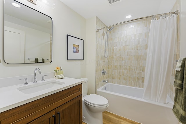 bathroom featuring vanity, toilet, wood finished floors, and shower / tub combo