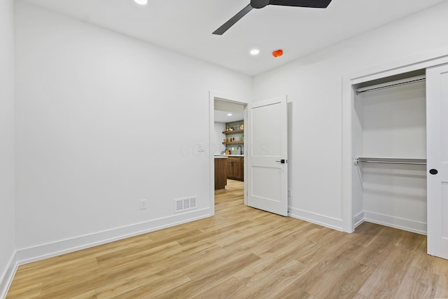 unfurnished bedroom with light wood-style flooring, baseboards, visible vents, and a closet