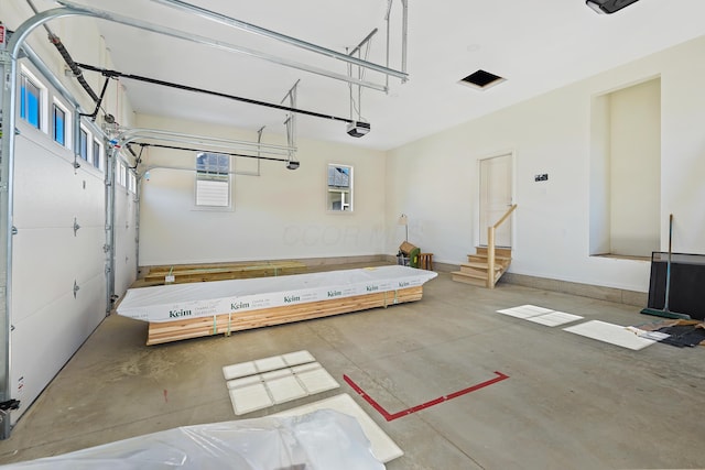 garage featuring a garage door opener and baseboards