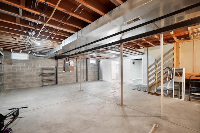 unfinished below grade area with electric panel and stairs