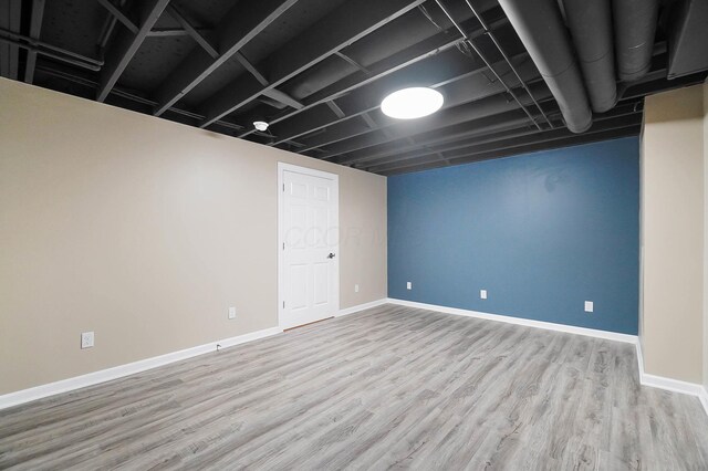 finished below grade area featuring wood finished floors and baseboards