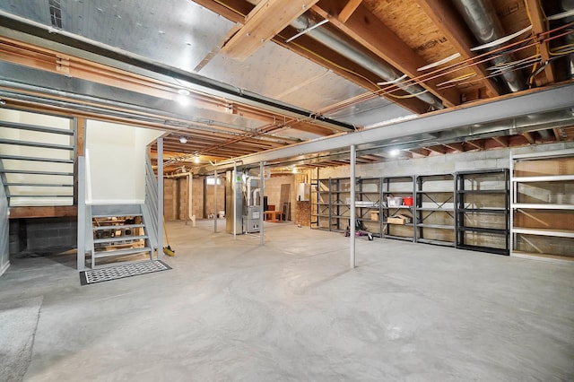 unfinished basement featuring stairway and heating unit
