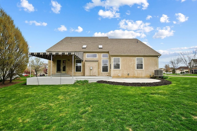 rear view of house with a patio, a lawn, central air condition unit, stucco siding, and a shingled roof
