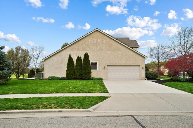 view of side of home featuring a lawn, stucco siding, a garage, and driveway