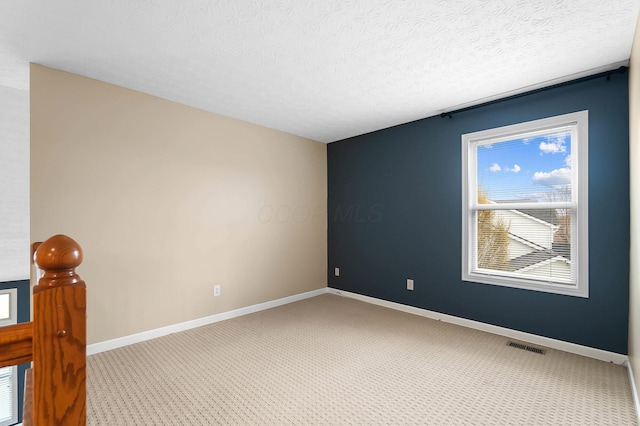 carpeted spare room featuring baseboards