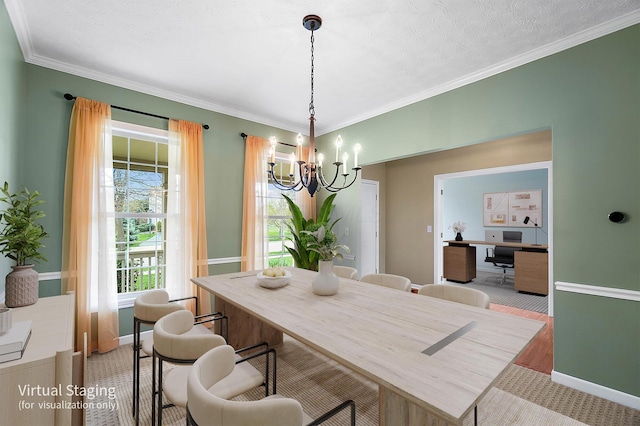 dining space with a chandelier, ornamental molding, and baseboards