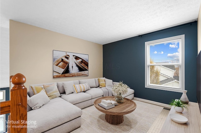 living area with baseboards and a textured ceiling