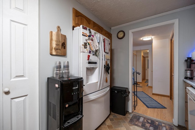 kitchen with brown cabinets, a textured ceiling, white refrigerator with ice dispenser, and stone finish floor