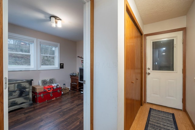 interior space with a textured ceiling and wood finished floors