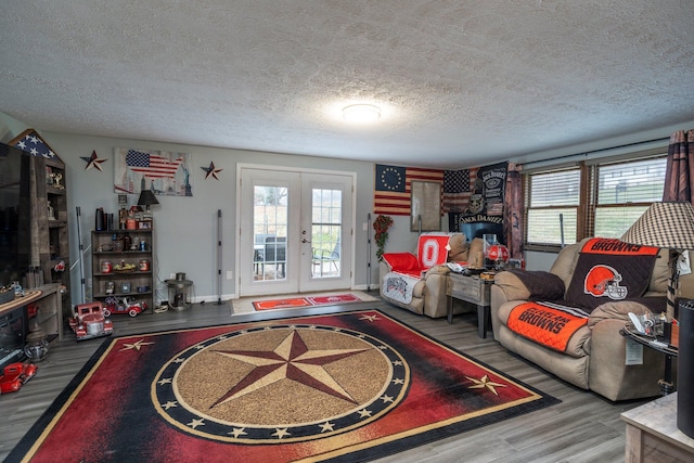 living area featuring french doors, a textured ceiling, baseboards, and wood finished floors