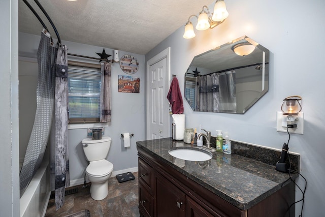bathroom with vanity, toilet, baseboards, and a textured ceiling