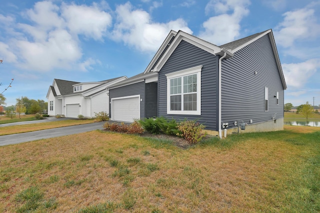 view of front of property featuring driveway, an attached garage, and a front lawn