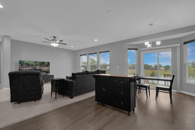 living area with recessed lighting, plenty of natural light, baseboards, and wood finished floors