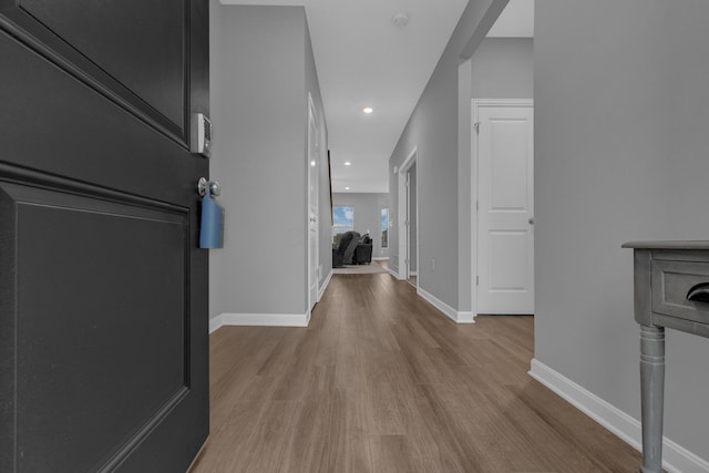 hallway with recessed lighting, baseboards, and wood finished floors