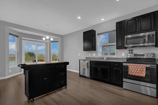 kitchen with a sink, dark cabinetry, and stainless steel appliances
