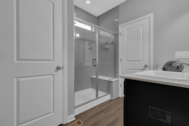 full bath with vanity, visible vents, wood finished floors, and a shower stall