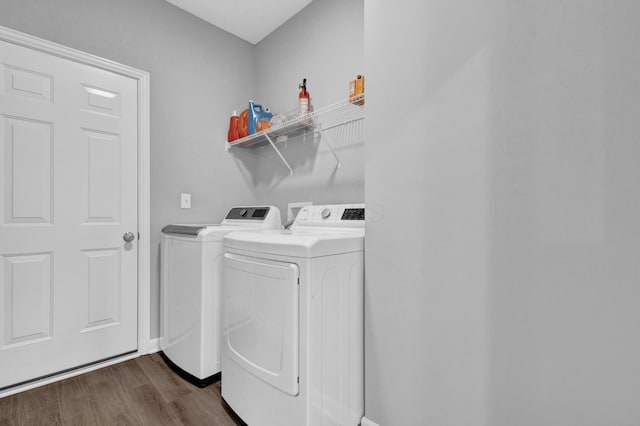 laundry room with dark wood-style floors, washing machine and clothes dryer, and laundry area