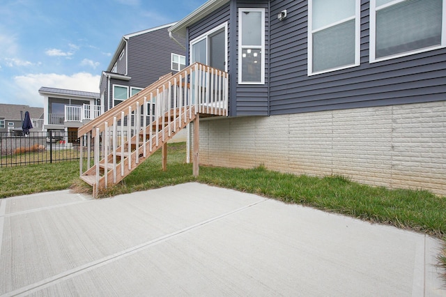 view of home's exterior with stairs, fence, and a patio area