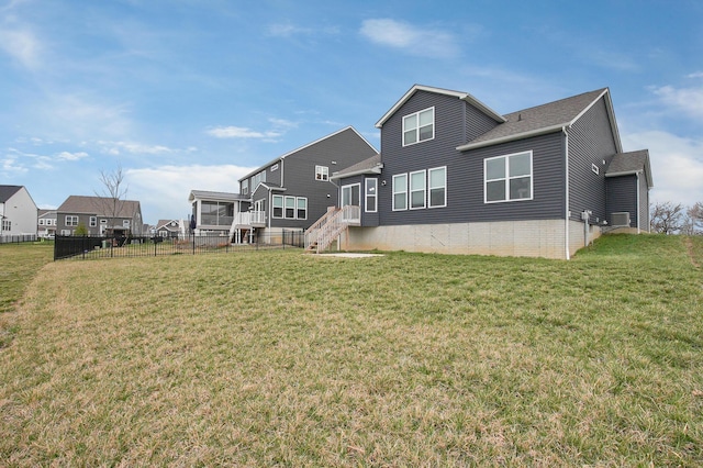 back of house featuring fence, cooling unit, a yard, and a residential view