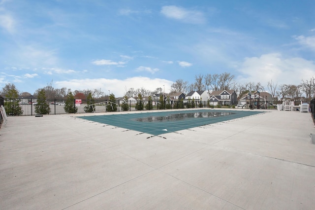 pool featuring a patio, fence, and a residential view
