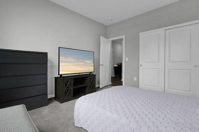 carpeted bedroom featuring baseboards and a closet