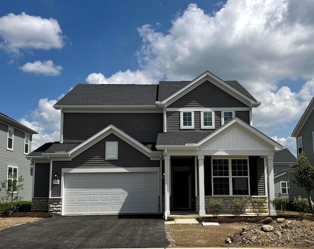 3780 Brody Dr Lot 187, Grove City, OH 43123 - view of front facade with stone siding, driveway, covered porch, and a garage