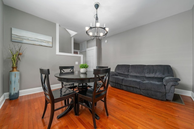 1542 S 4th St, Columbus, OH 43207 - dining room with wood finished floors, a chandelier, visible vents, and baseboards