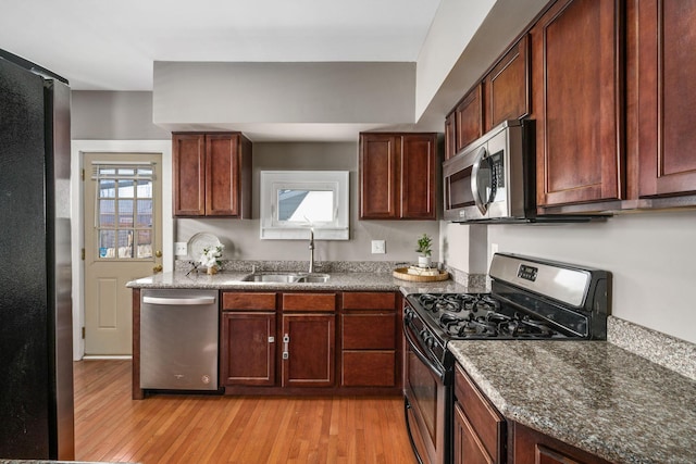 1542 S 4th St, Columbus, OH 43207 - kitchen with dark stone counters, stainless steel appliances, light wood-style flooring, and a sink