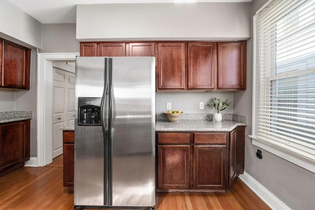 1542 S 4th St, Columbus, OH 43207 - kitchen with wood finished floors, baseboards, and stainless steel fridge with ice dispenser
