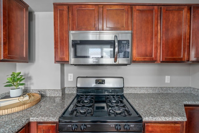 1542 S 4th St, Columbus, OH 43207 - kitchen featuring dark brown cabinets, range with gas stovetop, and stainless steel microwave