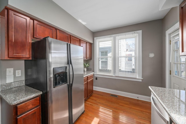 1542 S 4th St, Columbus, OH 43207 - kitchen featuring light wood-style flooring, visible vents, baseboards, dishwasher, and stainless steel fridge with ice dispenser