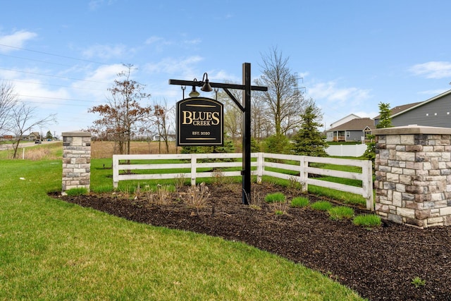 community sign featuring a yard and fence