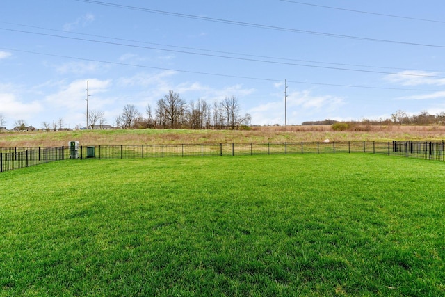 view of yard with fence and a rural view