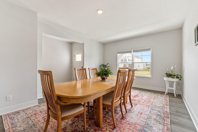 dining room featuring baseboards, light wood-style floors, and a healthy amount of sunlight