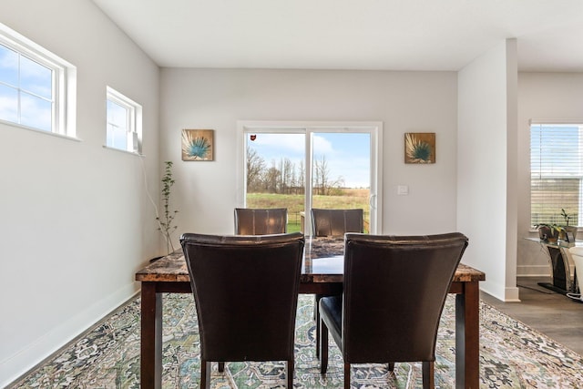 dining space featuring baseboards and wood finished floors