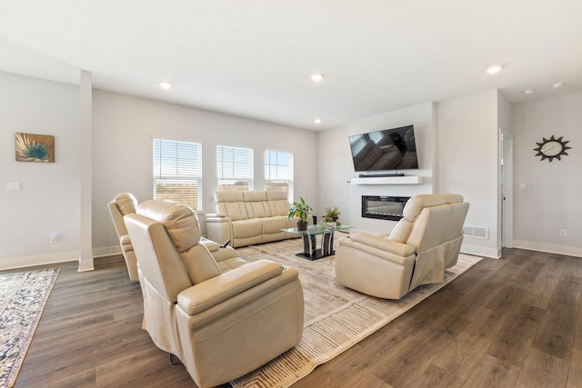 living room with baseboards, recessed lighting, wood finished floors, and a glass covered fireplace