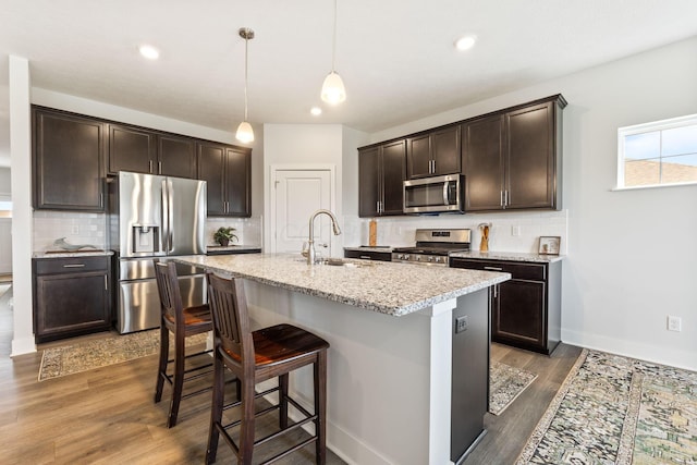 kitchen featuring a sink, dark brown cabinetry, appliances with stainless steel finishes, and dark wood-style floors