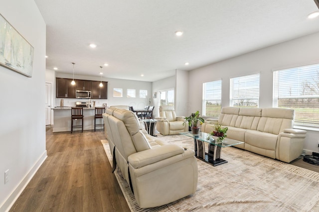 living area featuring plenty of natural light, baseboards, recessed lighting, and wood finished floors