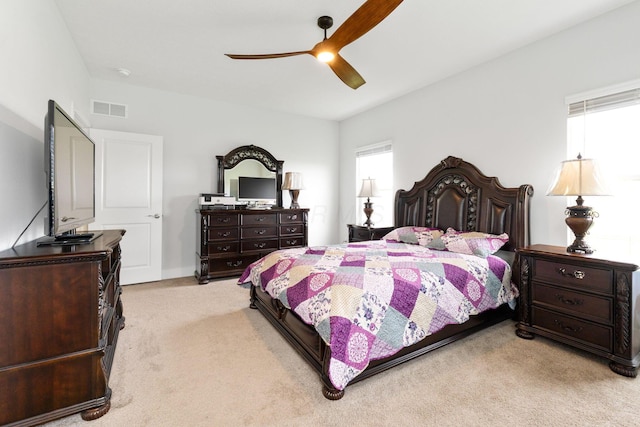 bedroom featuring light carpet, visible vents, and ceiling fan