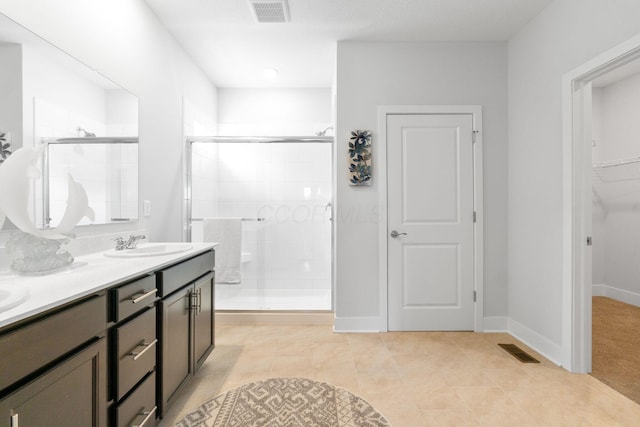 full bath featuring a shower stall, tile patterned floors, a sink, visible vents, and double vanity