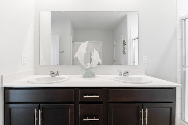 full bathroom featuring an enclosed shower, double vanity, and a sink